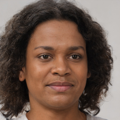 Joyful black young-adult female with medium  brown hair and brown eyes