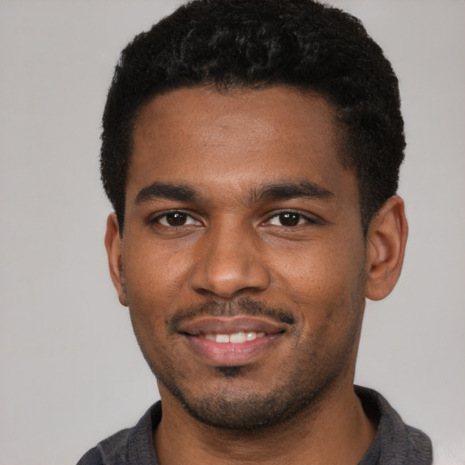 Joyful black young-adult male with short  black hair and brown eyes