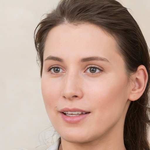 Joyful white young-adult female with medium  brown hair and grey eyes