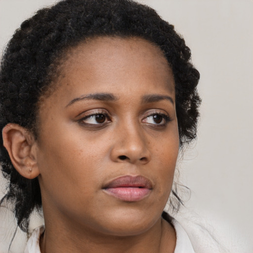 Neutral black young-adult female with medium  brown hair and brown eyes