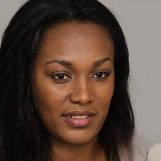 Joyful black young-adult female with long  brown hair and brown eyes
