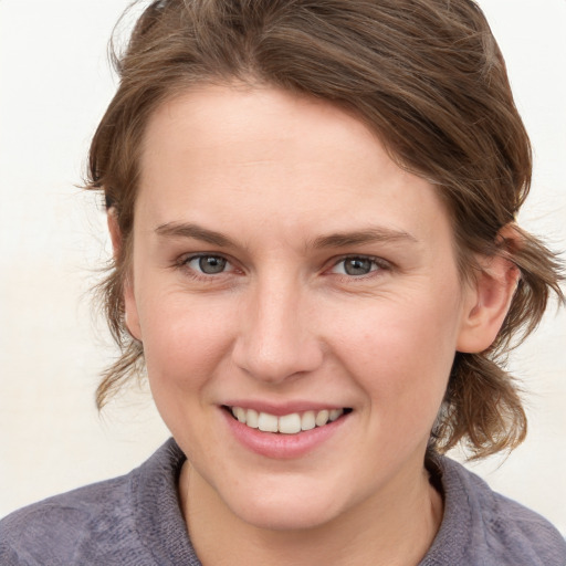 Joyful white young-adult female with medium  brown hair and grey eyes