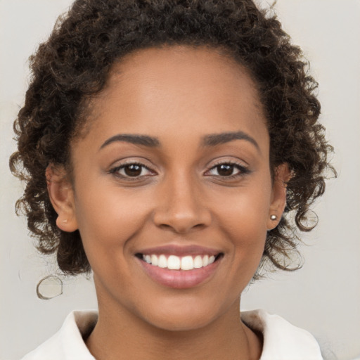 Joyful black young-adult female with medium  brown hair and brown eyes