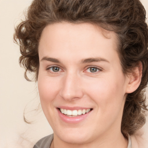 Joyful white young-adult female with medium  brown hair and green eyes