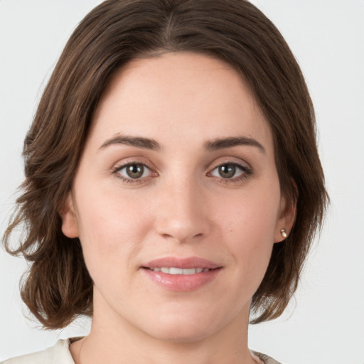 Joyful white young-adult female with medium  brown hair and green eyes