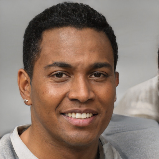 Joyful black young-adult male with short  black hair and brown eyes