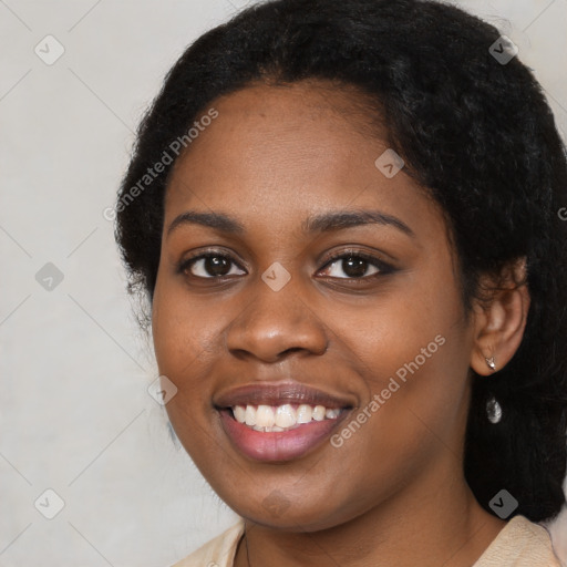 Joyful black young-adult female with long  black hair and brown eyes