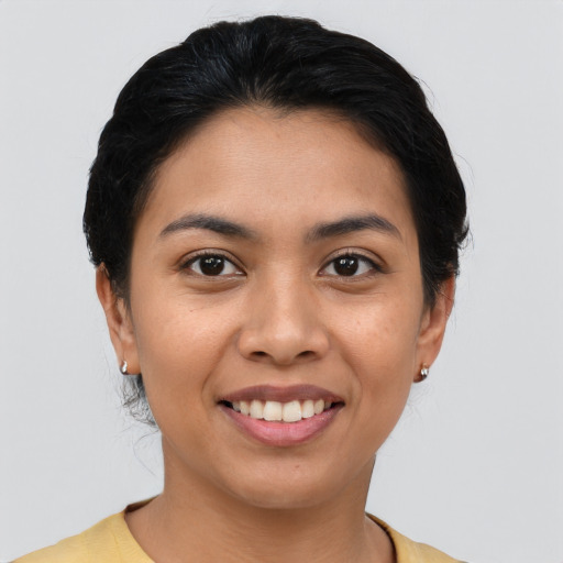 Joyful latino young-adult female with short  black hair and brown eyes
