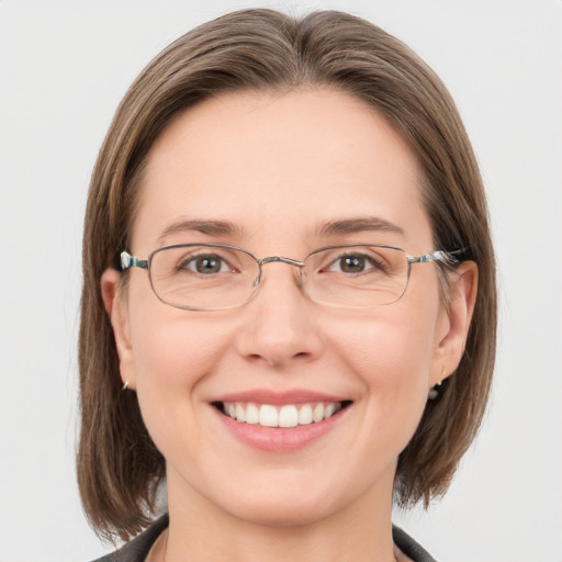 Joyful white adult female with medium  brown hair and grey eyes