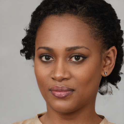 Joyful black young-adult female with short  brown hair and brown eyes
