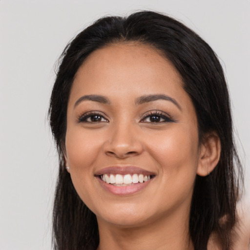 Joyful latino young-adult female with long  black hair and brown eyes