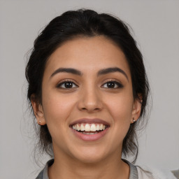 Joyful latino young-adult female with medium  brown hair and brown eyes