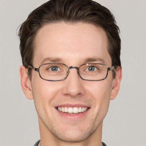 Joyful white young-adult male with short  brown hair and grey eyes