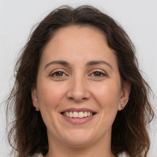 Joyful white adult female with long  brown hair and grey eyes