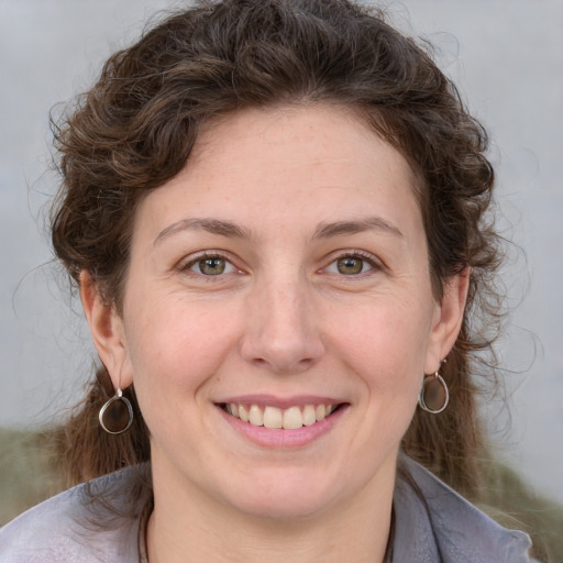 Joyful white young-adult female with medium  brown hair and green eyes