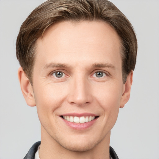 Joyful white young-adult male with short  brown hair and grey eyes