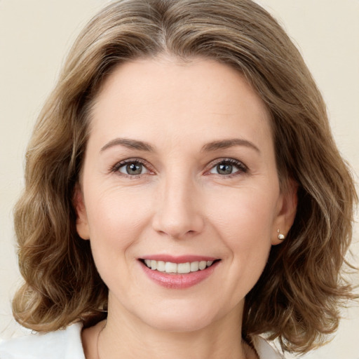 Joyful white young-adult female with medium  brown hair and green eyes