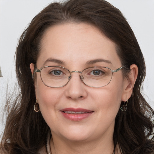 Joyful white adult female with long  brown hair and grey eyes