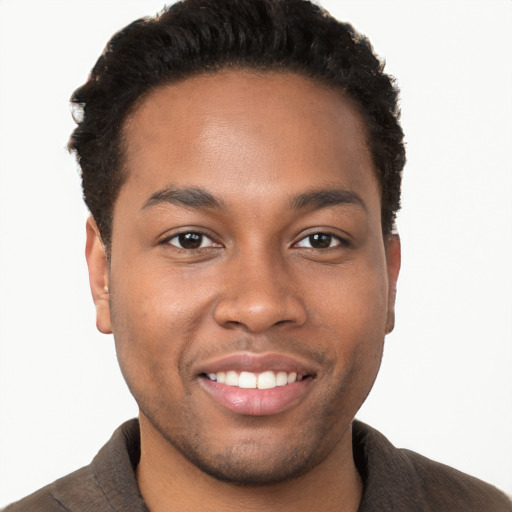 Joyful black young-adult male with short  brown hair and brown eyes