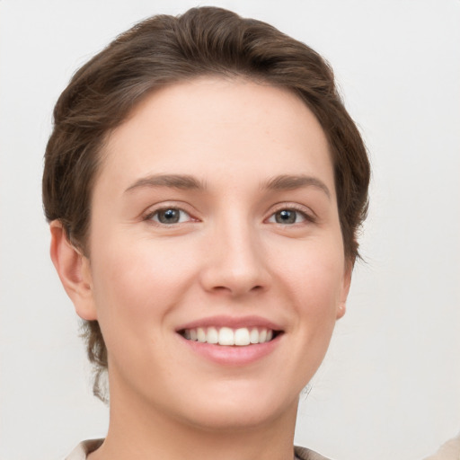 Joyful white young-adult female with short  brown hair and grey eyes