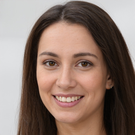 Joyful white young-adult female with long  brown hair and brown eyes