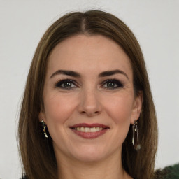 Joyful white young-adult female with long  brown hair and green eyes