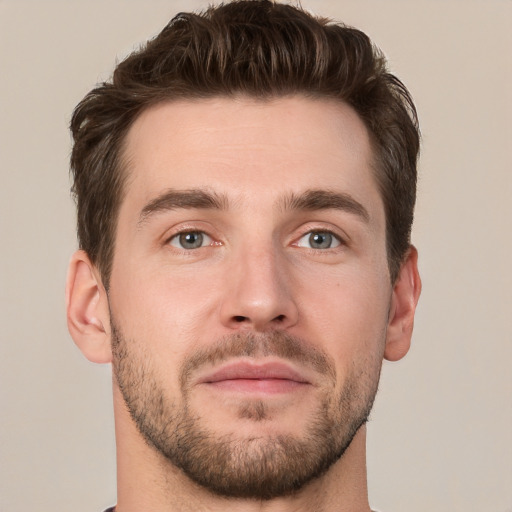 Joyful white young-adult male with short  brown hair and grey eyes