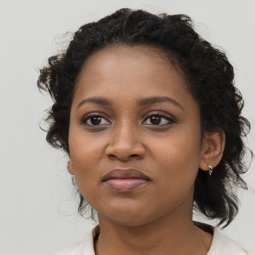 Joyful black young-adult female with medium  brown hair and brown eyes