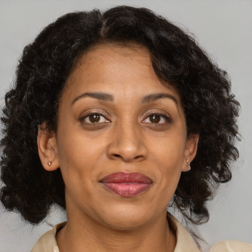 Joyful black adult female with medium  brown hair and brown eyes