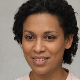 Joyful latino adult female with medium  brown hair and brown eyes