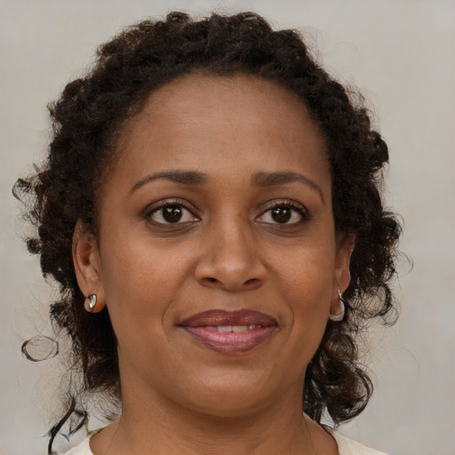 Joyful black adult female with medium  brown hair and brown eyes