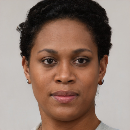 Joyful black young-adult female with short  black hair and brown eyes