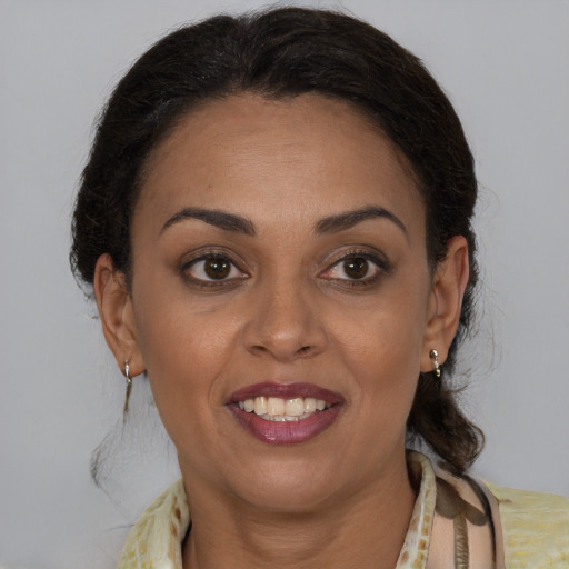 Joyful latino adult female with medium  brown hair and brown eyes