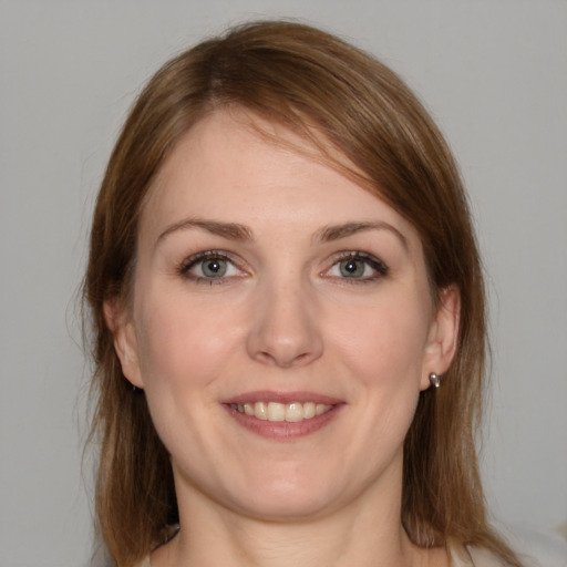 Joyful white young-adult female with medium  brown hair and grey eyes