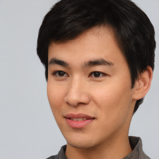 Joyful asian young-adult male with short  brown hair and brown eyes
