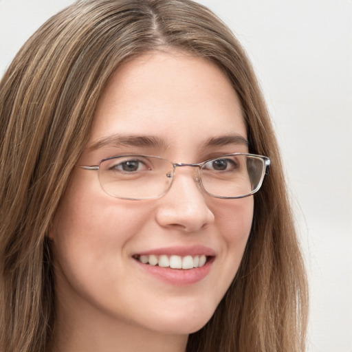 Joyful white young-adult female with long  brown hair and green eyes