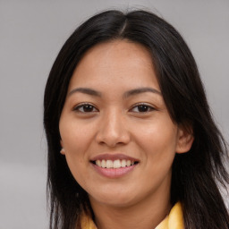 Joyful latino young-adult female with long  brown hair and brown eyes