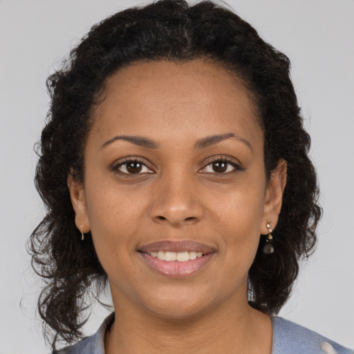 Joyful black young-adult female with medium  brown hair and brown eyes