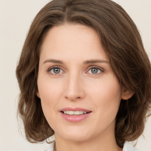 Joyful white young-adult female with medium  brown hair and green eyes