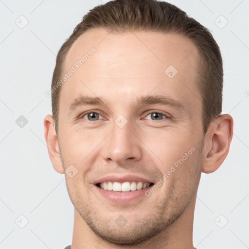 Joyful white young-adult male with short  brown hair and grey eyes