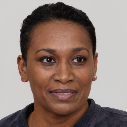 Joyful black adult female with short  black hair and brown eyes