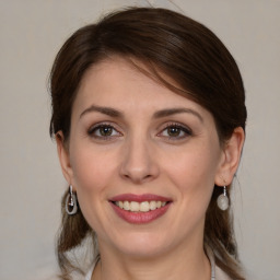 Joyful white young-adult female with medium  brown hair and grey eyes