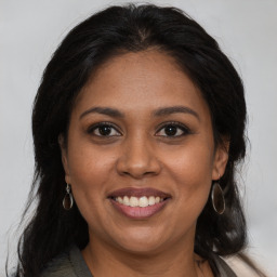 Joyful black adult female with medium  brown hair and brown eyes