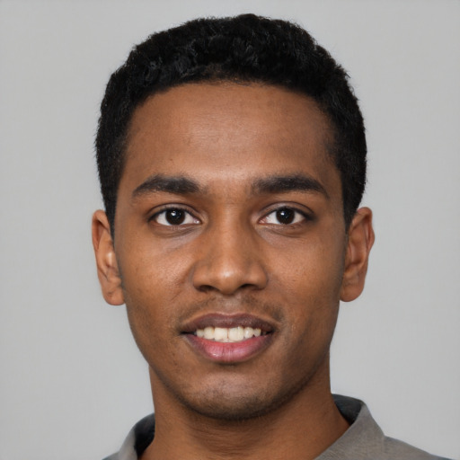 Joyful black young-adult male with short  black hair and brown eyes
