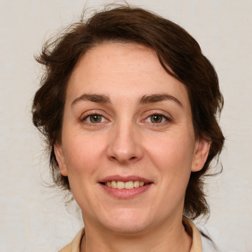 Joyful white adult female with medium  brown hair and green eyes