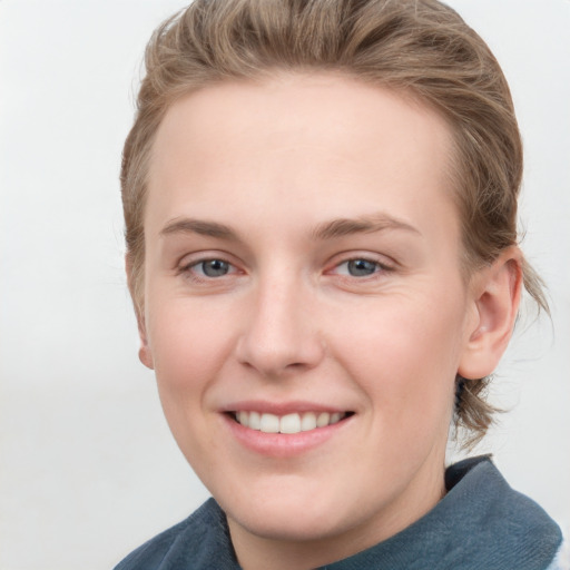 Joyful white young-adult female with short  brown hair and blue eyes