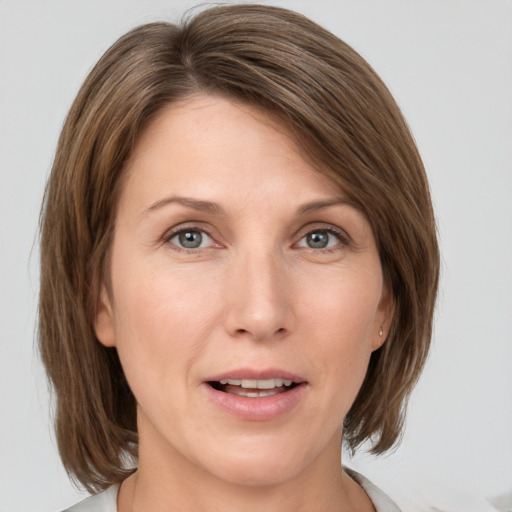 Joyful white adult female with medium  brown hair and grey eyes