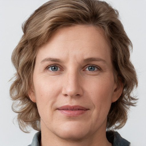 Joyful white adult female with medium  brown hair and grey eyes