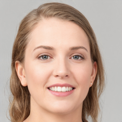 Joyful white young-adult female with medium  brown hair and grey eyes