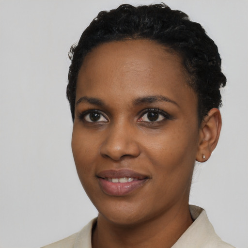 Joyful black young-adult female with short  black hair and brown eyes